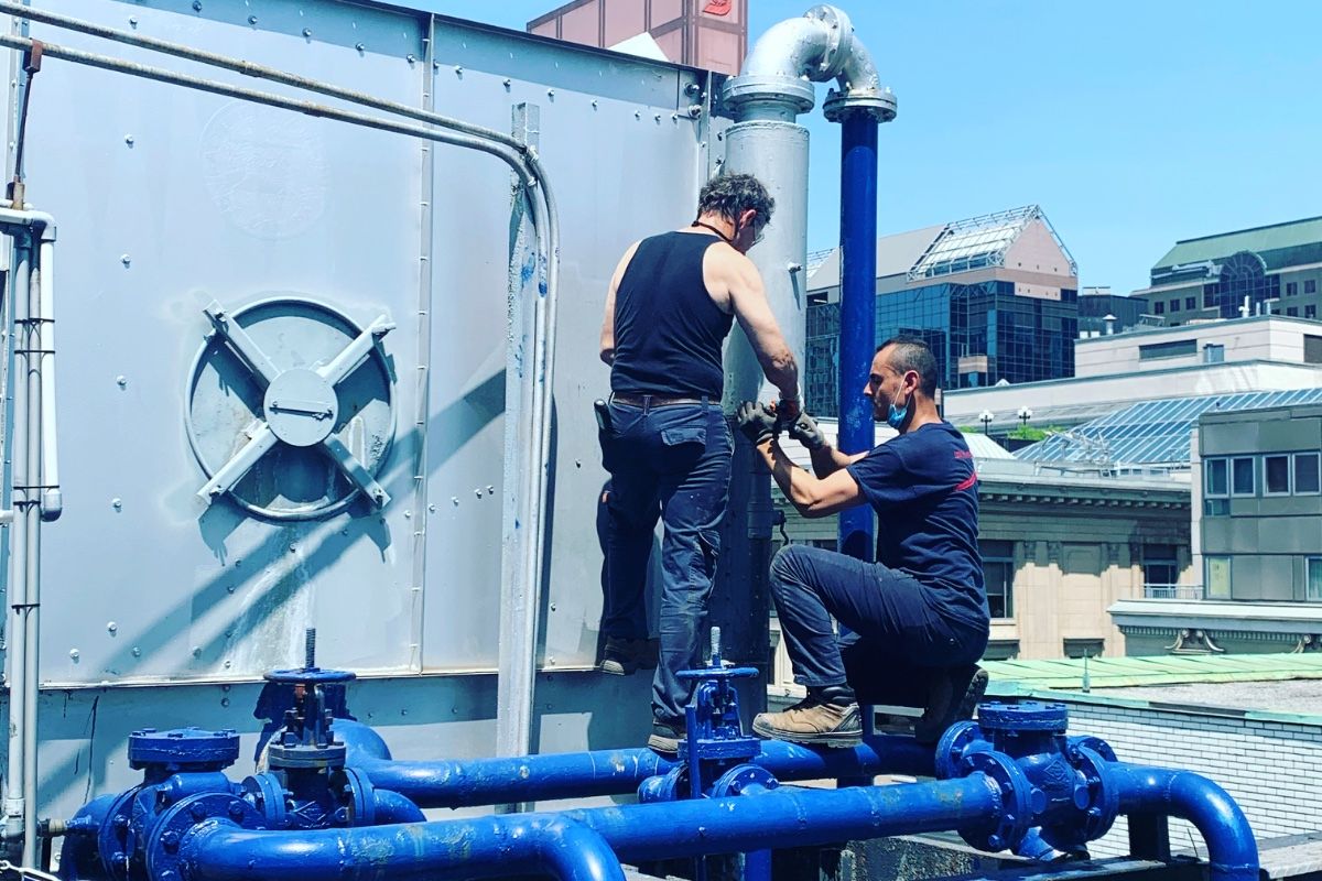 Techniciens de Solutions Controlium travaillant à une tour de refroidissement au centre-ville de Montréal