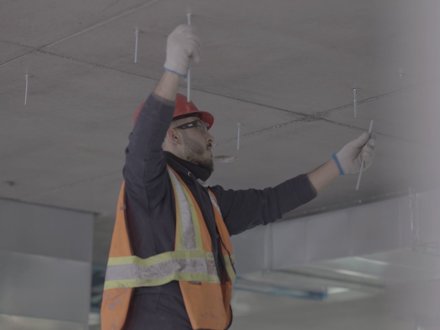 A technician installing a ceiling unit indoors