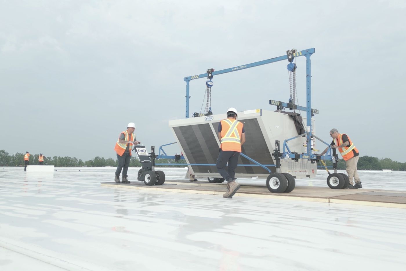 Controlium crew positioning a rooftop unit with a gantry